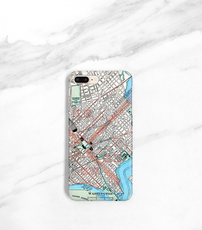 May include: A white iPhone case featuring a vintage map of Washington, D.C. printed on it. The map depicts the city's streets, parks, and waterways. The case has a gold trim around the edges.