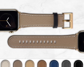 Può includere: Un cinturino per Apple Watch in pelle beige con cuciture bianche e fibbia dorata. Il cinturino ha una serie di fori per regolare la vestibilità. Il cinturino è mostrato su uno sfondo di marmo bianco. Altre opzioni di colore sono mostrate di seguito.