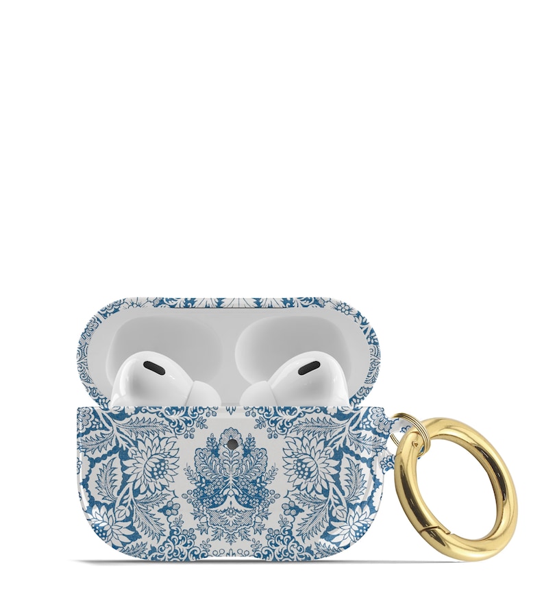 Peut inclure: &Eacute;tui blanc pour Airpods avec un motif floral bleu et blanc et un anneau en m&eacute;tal dor&eacute;.
