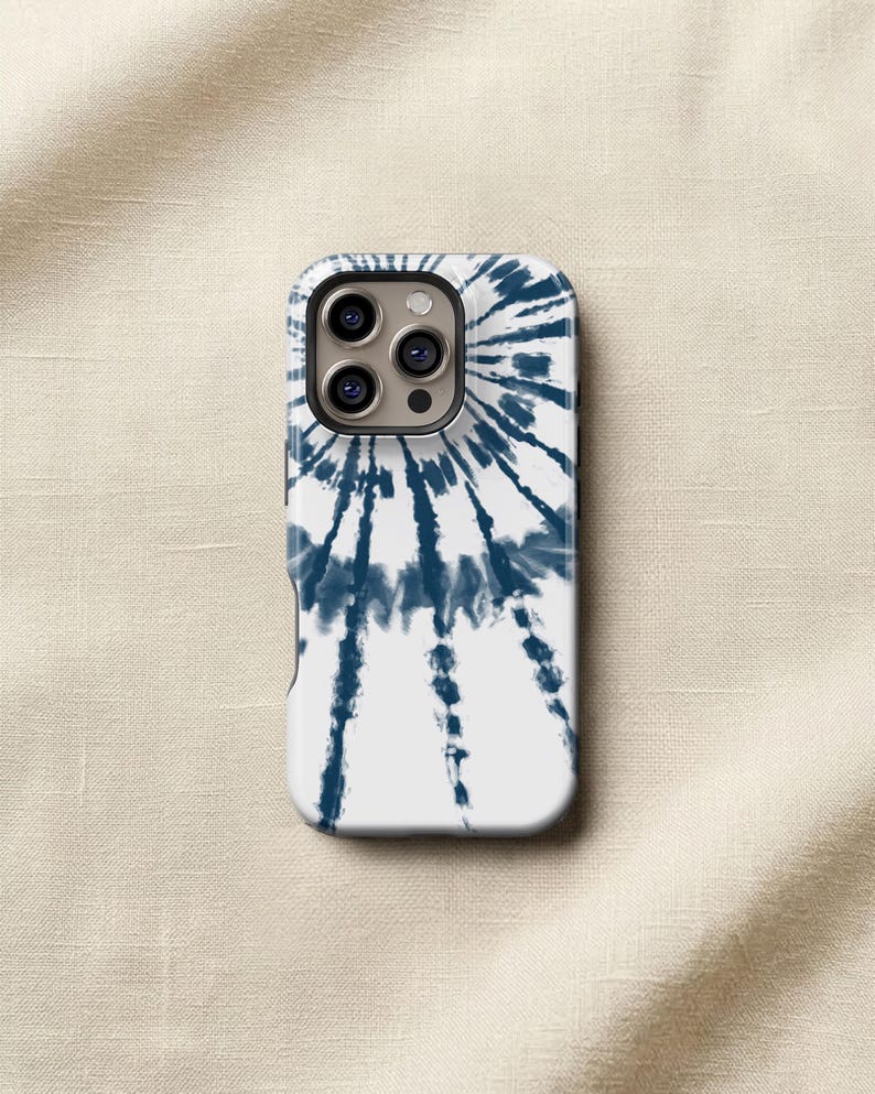 a white phone case with a tie-dye pattern on it, placed on a beige fabric background.