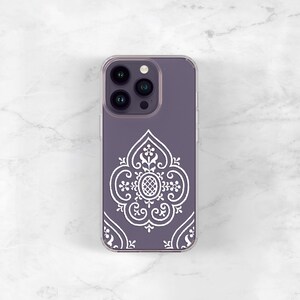 May include: A clear phone case with a purple background and a white intricate design. The case has a cutout for the phone's camera lenses.