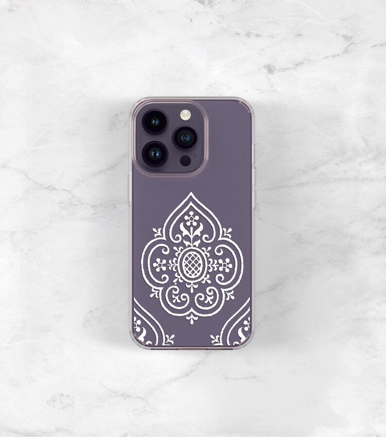 May include: A clear phone case with a purple background and a white intricate design. The case has a cutout for the phone's camera lenses.