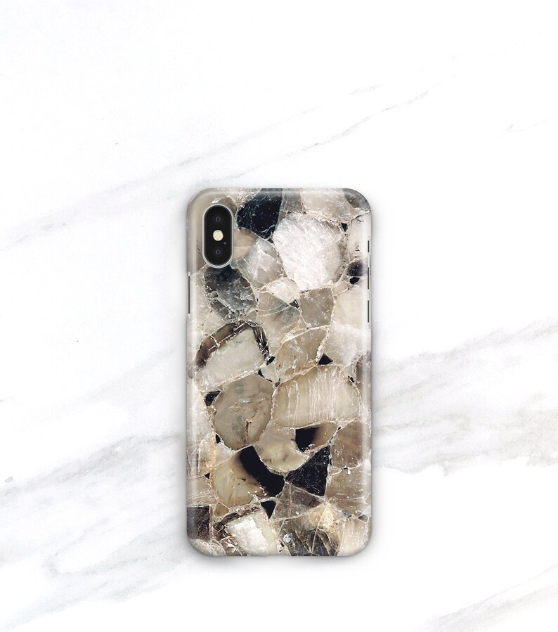 May include: A phone case with a brown and white abstract pattern. The pattern resembles a mosaic of small, irregular shapes.