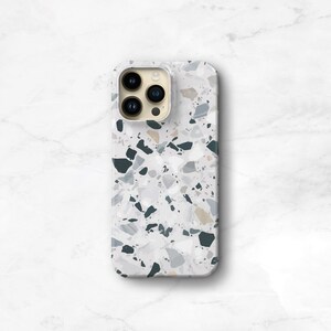 A phone case with a terrazzo pattern. The case is on an iphone