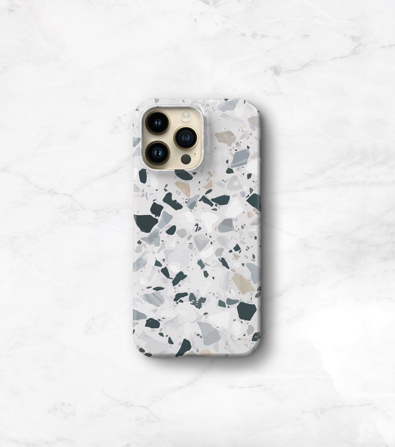 A phone case with a terrazzo pattern. The case is on an iphone