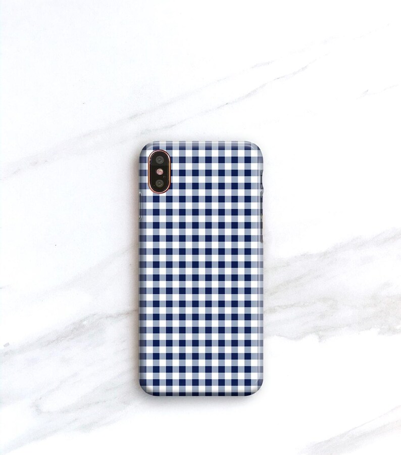 Pu&ograve; includere: Una custodia per smartphone con un motivo a quadretti blu navy e bianco. La custodia ha una forma rettangolare con angoli arrotondati e un ritaglio per la fotocamera. Il design &egrave; un classico motivo a quadretti, che offre un aspetto semplice ma elegante.
