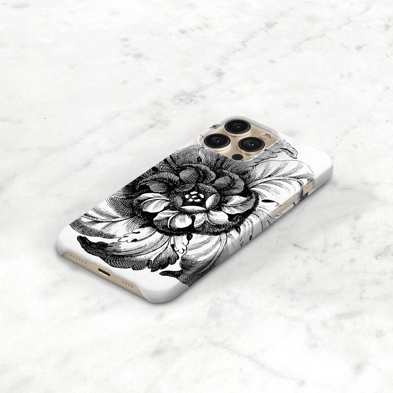 May include: White phone case featuring a detailed black and white floral design. The illustration depicts a large, open flower with intricate petal details. The case has a glossy finish and a camera bump.