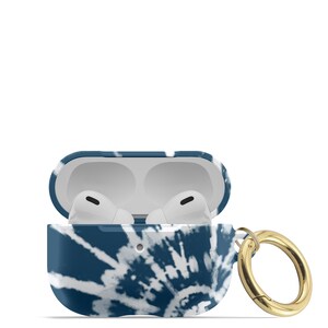 May include: A blue and white tie-dye patterned protective case for AirPods with a gold metal carabiner.