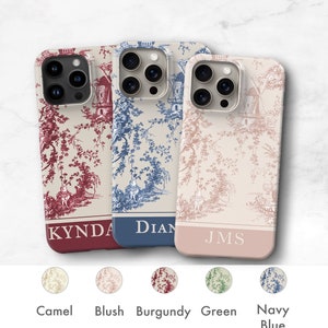 May include: Three phone cases with a toile pattern in burgundy, blue, and blush. The cases have a personalized name on the bottom: Kynda, Dian, and Jms. The cases are shown against a white background with five color swatches below: camel, blush, burgundy, green, and navy blue.
