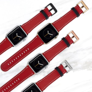 May include: Four Apple Watch bands in red leather with white stitching and black metal clasps. The bands are shown on different coloured Apple Watch faces.