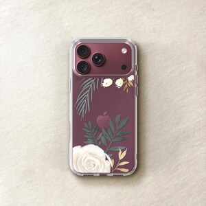 a clear phone case with a floral design on it, placed on a beige surface.