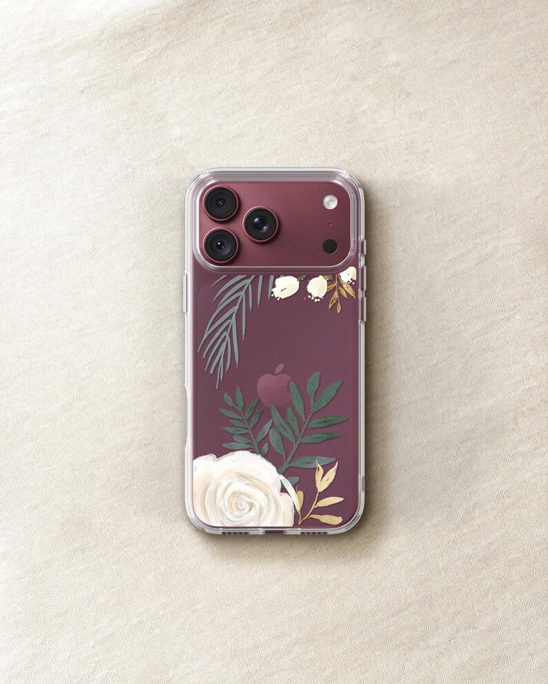 a clear phone case with a floral design on it, placed on a beige surface.