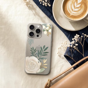 a smartphone with a floral design on its case, a cup of coffee, a purse, and some white flowers.