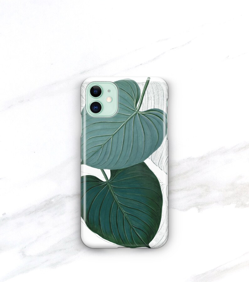 May include: A white phone case with a green leaf design. The leaves are detailed and realistic, with a light green background.