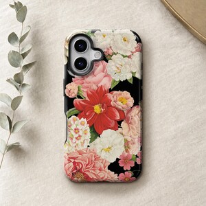 a phone case with a floral design, including red and pink flowers, placed on a beige surface.