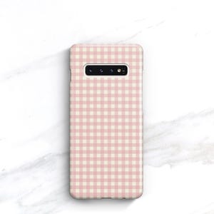 Pu&ograve; includere: Custodia per telefono con motivo a quadretti rosa e bianco. La custodia rettangolare &egrave; progettata per uno smartphone, con ritagli per la fotocamera e altre funzioni. Realizzata in materiale liscio, ha bordi arrotondati.