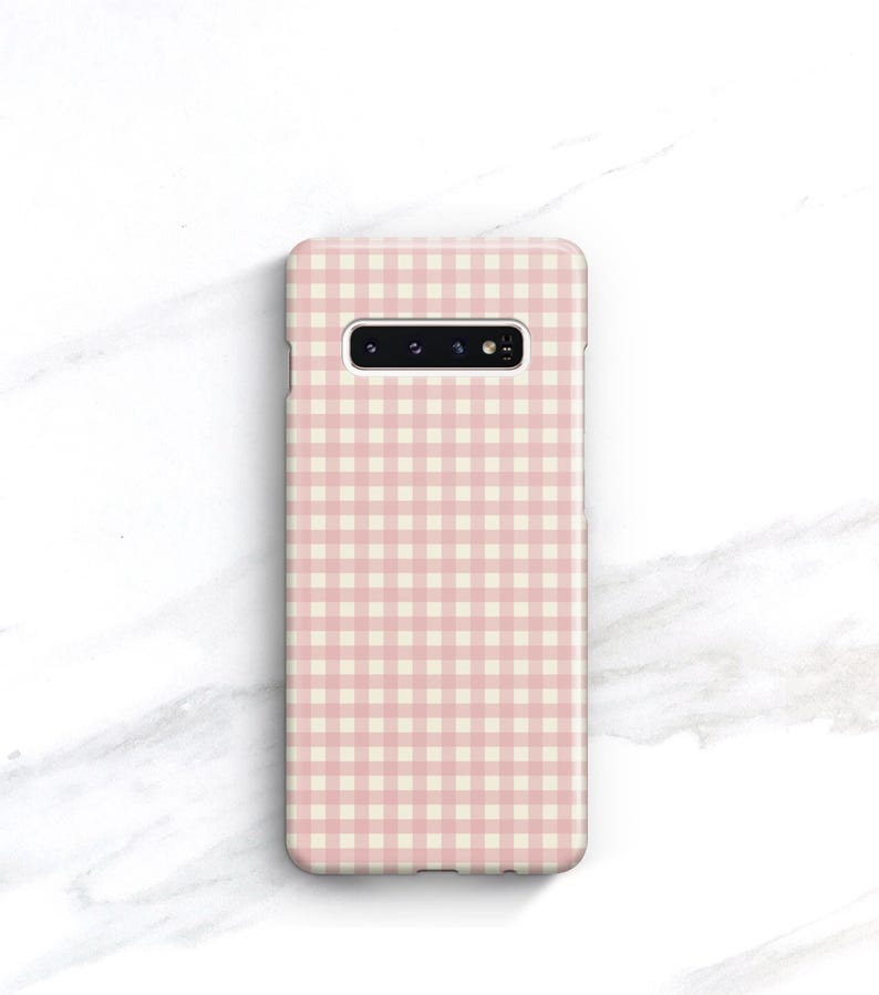 Pu&ograve; includere: Custodia per telefono con motivo a quadretti rosa e bianco. La custodia rettangolare &egrave; progettata per uno smartphone, con ritagli per la fotocamera e altre funzioni. Realizzata in materiale liscio, ha bordi arrotondati.