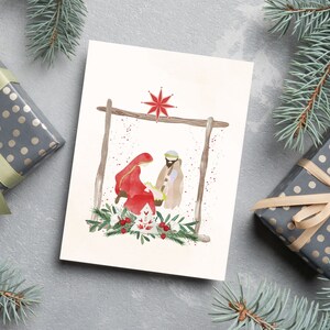 May include: A watercolor Christmas card featuring a nativity scene with Mary, Joseph, and baby Jesus in a manger. The scene is set against a white background with a red star above the manger.