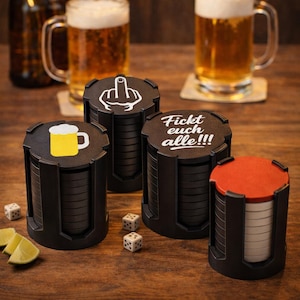 Könnte beinhalten: Vier schwarze Untersetzer mit verschiedenen Designs und Texten, darunter ein Bierkrug, ein Mittelfinger und der Satz "Fickt euch alle!!!". Die Untersetzer sind gestapelt und von Würfeln, Bier und Limettenspalten auf einer Holzoberfläche umgeben.