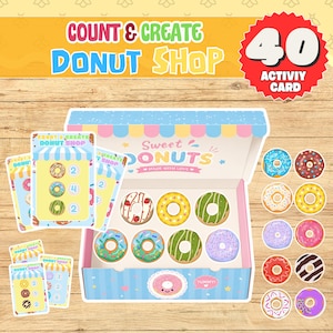 May include: A Count & Create Donut Shop activity set featuring 40 activity cards, a box labeled Sweet Donuts, and various donut-shaped cutouts in colors including pink, green, blue, yellow, and brown with assorted toppings and sprinkles.