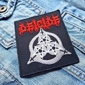 May include: Black embroidered patch with the word "DECIDE" in red lettering and a white pentagram design.