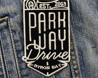 May include: Black and white embroidered patch with the text "Parkway Drive" and "Byron Bay" in a vintage style. The patch also includes the text "Est. 2003" and a logo.