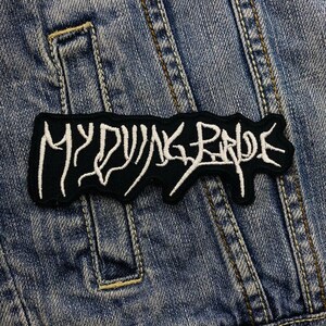 Könnte beinhalten: Schwarzer und weißer gestickter Patch mit dem Text "MY DYING BRIDE" auf einer Jeansjacke.
