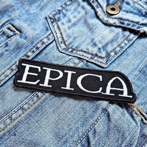 Op de afbeelding: Een geborduurde zwarte en witte patch met het woord "EPICA" in witte letters op een zwarte achtergrond.