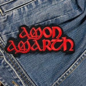 Könnte beinhalten: Roter und schwarzer gestickter Aufnäher mit dem Text "Deon Warth" auf einem blauen Jeansstoff.