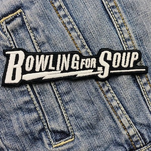 Pode incluir: Um remendo bordado preto e branco com o texto "Bowling for Soup" em um fundo de jeans.