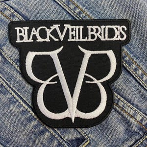 Könnte beinhalten: Schwarzer und weißer gestickter Patch mit dem Text "Black Veil Brides" und einem stilisierten "V"-Logo.