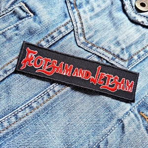 May include: A black and red embroidered patch with the text "Fotsam and Jetsam" in red lettering.
