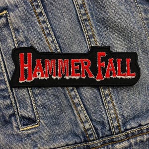 May include: Black and red embroidered patch with the text "HAMMERFALL" in white lettering.