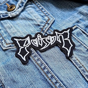 Könnte beinhalten: Schwarzer und weißer gestickter Patch mit dem Wort "Poison" in einer stilisierten Schriftart. Der Patch ist auf eine blaue Jeansjacke genäht.