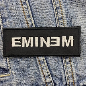 May include: Black patch with white embroidered text that reads "EMINEM".