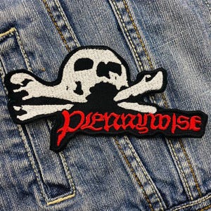 May include: An embroidered patch featuring a white and black skull and crossbones with the word "Otherwise" in red lettering.
