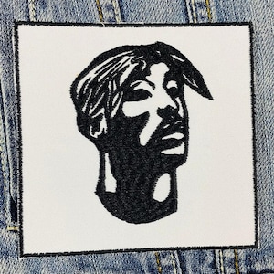 Puede incluir: Parche bordado en blanco y negro de la cara de una persona. La persona mira hacia la derecha y tiene un peinado corto.