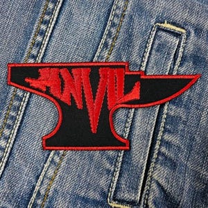 Op de afbeelding: Een zwart en rood geborduurde patch in de vorm van een aambeeld met het woord "ANVIL" in rode letters.