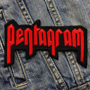 May include: A black and red embroidered patch with the word "Pentagram" in red lettering. The patch is on a blue denim background.