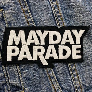 May include: Black and white embroidered patch with the text "MAYDAY PARADE" in a bold, stylized font.