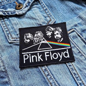 Könnte beinhalten: Schwarzer und weißer gestickter Patch mit dem Namen der Band Pink Floyd und einem stilisierten Bild eines Prismas und vier Gesichtern.