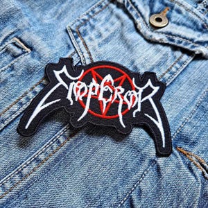 May include: Black and white embroidered patch with the word "Emperor" in a stylized font. A red pentagram is in the center of the patch.