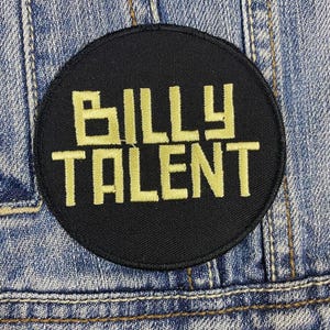 Op de afbeelding: Een geborduurde zwarte en gouden patch met de tekst "BILLY TALENT" op een zwarte ronde achtergrond.
