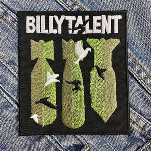 Könnte beinhalten: Schwarz-weiß gestickter Patch mit dem Text "BILLY TALENT" in Weiß. Der Patch zeigt drei grüne Bomben mit weißen und schwarzen Vögeln, die um sie herum fliegen.