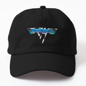 May include: Black baseball cap featuring the Van Halen logo in silver, blue, and yellow. The logo is a stylized design with the band's name. The cap has a curved brim and an adjustable strap.