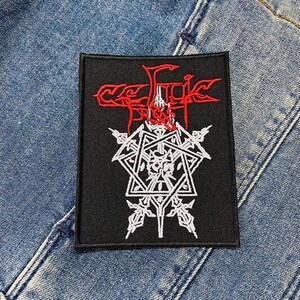 以下が含まれることがあります： 黒と白の刺繍パッチで、赤い文字で「Celtic Frost」と書いてあります。パッチには、中央に頭蓋骨のある五芒星が描かれています。