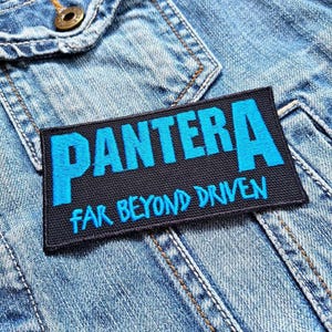 May include: Black and blue embroidered patch with the text "Pantera" and "Far Beyond Driven".
