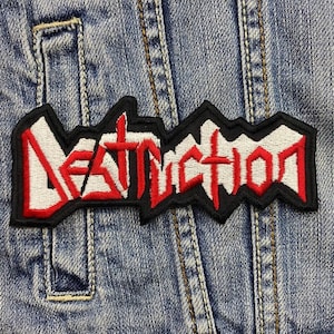 Op de afbeelding: Een zwarte en rode geborduurde patch met het woord "DESTRUCTION" in witte letters.