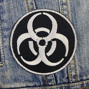 May include: A black and white biohazard symbol embroidered patch. The symbol is white on a black background.