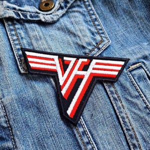 May include: A red, white, and black iron-on patch with the letters "VH" in a stylized font. The patch is shaped like a wing and has three white stripes on each side.